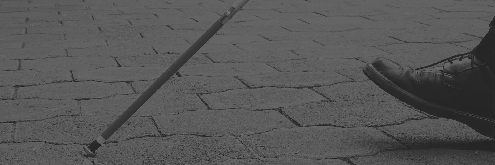 Blind person's cane against brick street